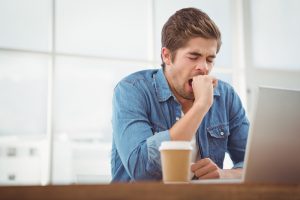 man tired at work yawning
