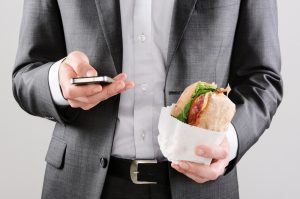 businessman on the go holding sandwich
