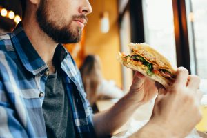 man slowly consuming his sandwich